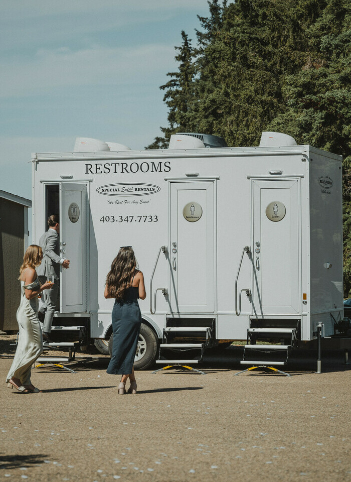 People walking towards one of the Luxury Portable Washroom Trailers