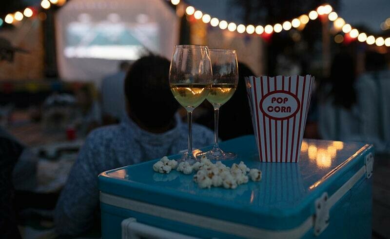 Special Event Rentals - Red Deer -- Family Event Rentals featuring a backyard movie with popcorn and white wine glasses